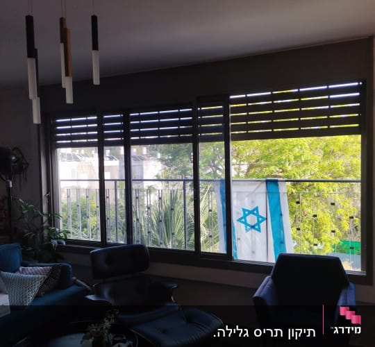 תריסים פתוחים למחצה בחלון גדול בסלון